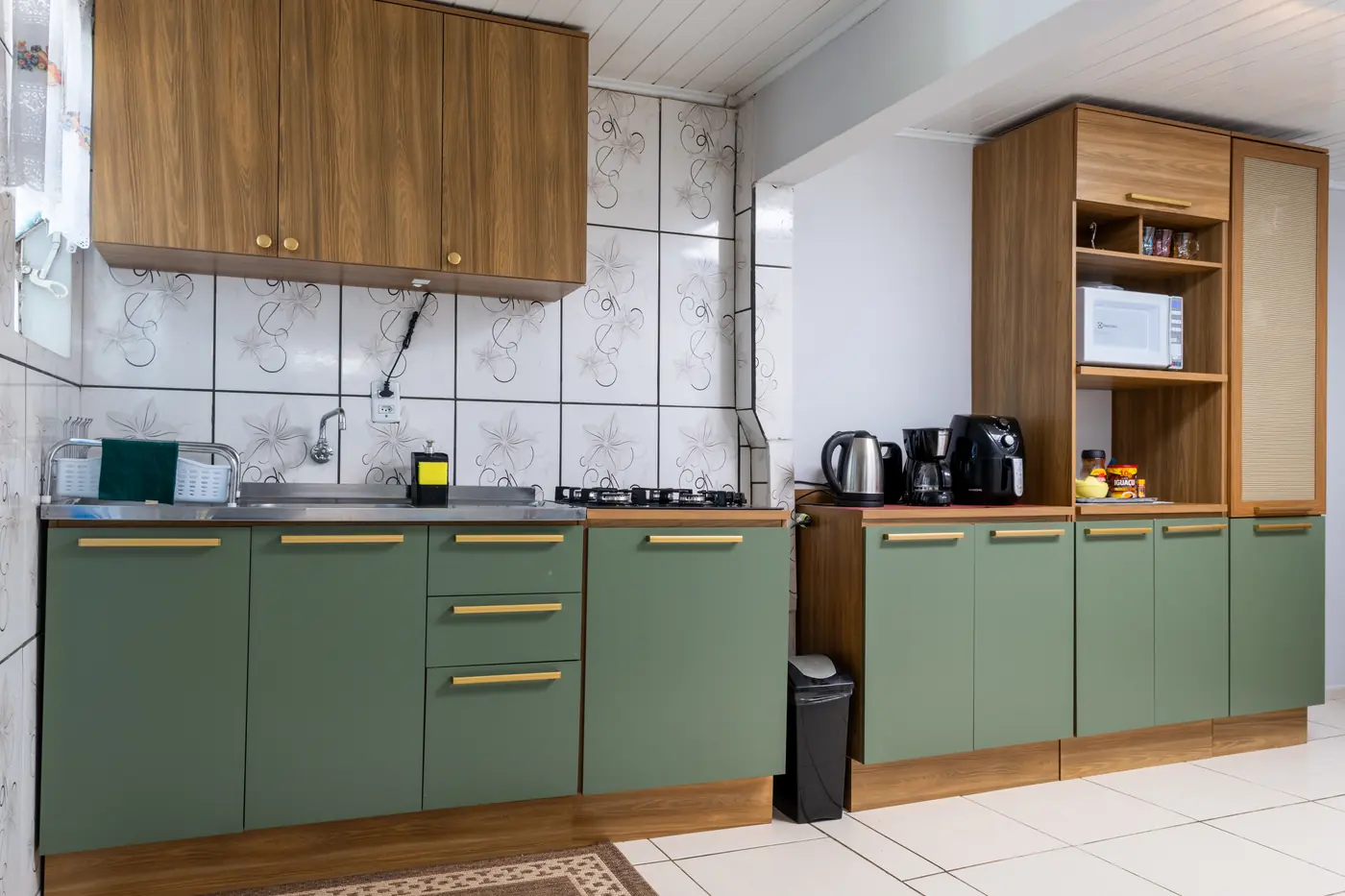 Cozinha compartilhada equipada com fogão, microondas e cafeteira